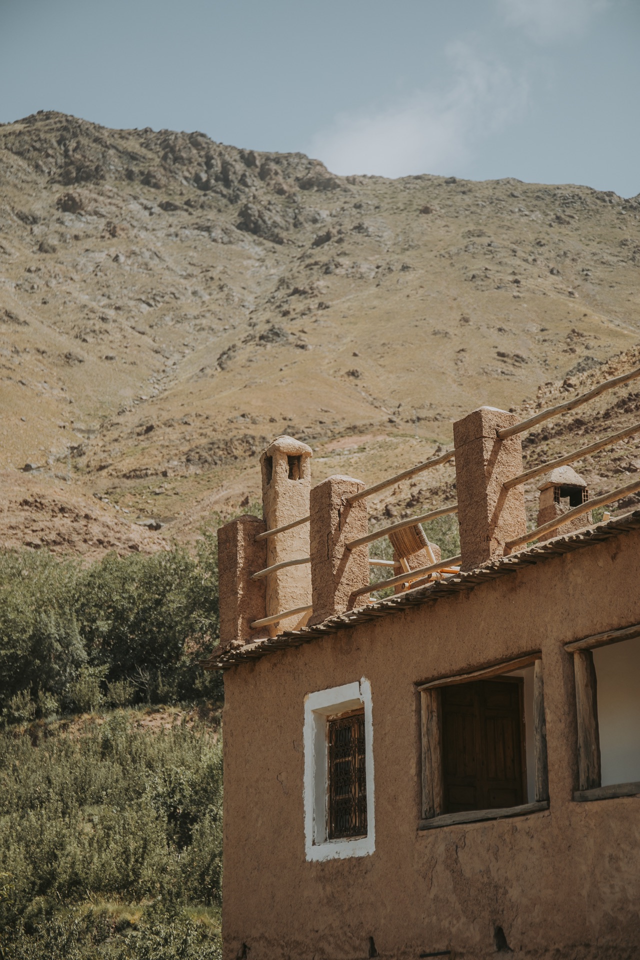 Maison de pisé et sa terrasse-toit face à la montagne nue