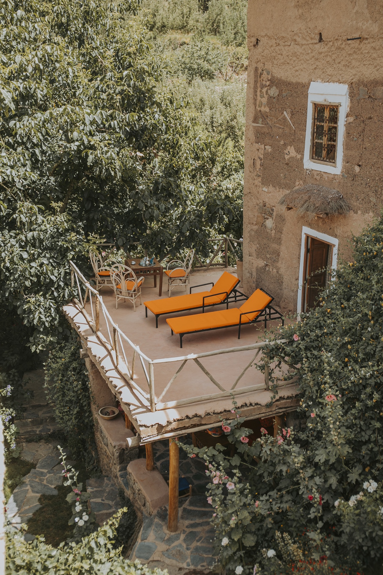 Terrasse ensoleillée aux transats, nichée dans la verdure du jardin